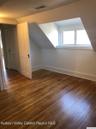 Additional living space with dark wood-style floors and vaulted ceiling