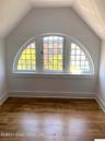 Bonus room with healthy amount of natural light, dark wood-style floors, and vaulted ceiling