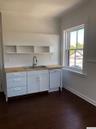 Kitchen featuring wood counters, white cabinetry, white dishwasher, and open shelves