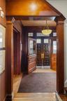 Foyer with light wood-type flooring, french doors, ornamental molding, and decorative columns