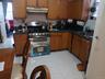 Kitchen with decorative backsplash, double oven range, and brown cabinets