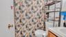 Full bath featuring toilet, vanity, and a shower with shower curtain