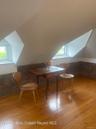 Bonus room featuring brick wall, lofted ceiling, light wood-style flooring, and healthy amount of natural light