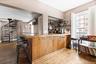 Indoor dry bar with dark wood-type flooring, open shelves, stairway, and wooden counters