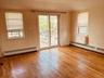 Spare room featuring a baseboard radiator, light wood finished floors, and plenty of natural light