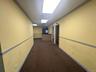 Hall featuring dark colored carpet and a drop ceiling