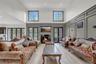 Living area with a decorative wall, light wood finished floors, french doors, ornamental molding, and a glass covered fireplace