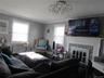 Living room with radiator heating unit, a fireplace, and crown molding