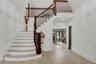 Stairs with a decorative wall, a high ceiling, and wood finished floors
