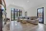 Living room featuring a fireplace with raised hearth, french doors, light wood finished floors, healthy amount of natural light, and recessed lighting