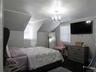Bedroom featuring vaulted ceiling and a chandelier