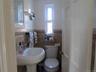 Half bathroom featuring a wainscoted wall and tile walls