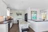 Kitchen featuring white cabinetry, a kitchen island, dark wood-style floors, recessed lighting, and wooden walls