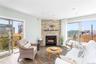Living area with wood finished floors, a stone fireplace, and recessed lighting