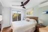 Bedroom featuring a wall mounted AC, access to exterior, dark wood-type flooring, and ceiling fan