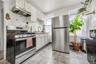 Kitchen with stainless steel appliances, decorative backsplash, under cabinet range hood, white cabinets, and light countertops