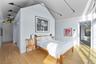 Bedroom featuring multiple windows, vaulted ceiling, light wood-style flooring, track lighting, and a baseboard heating unit