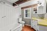 Bathroom with dark wood-style floors, vanity, beam ceiling, and tub / shower combination