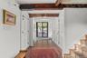 Doorway featuring beamed ceiling, wood-type flooring, and stairs