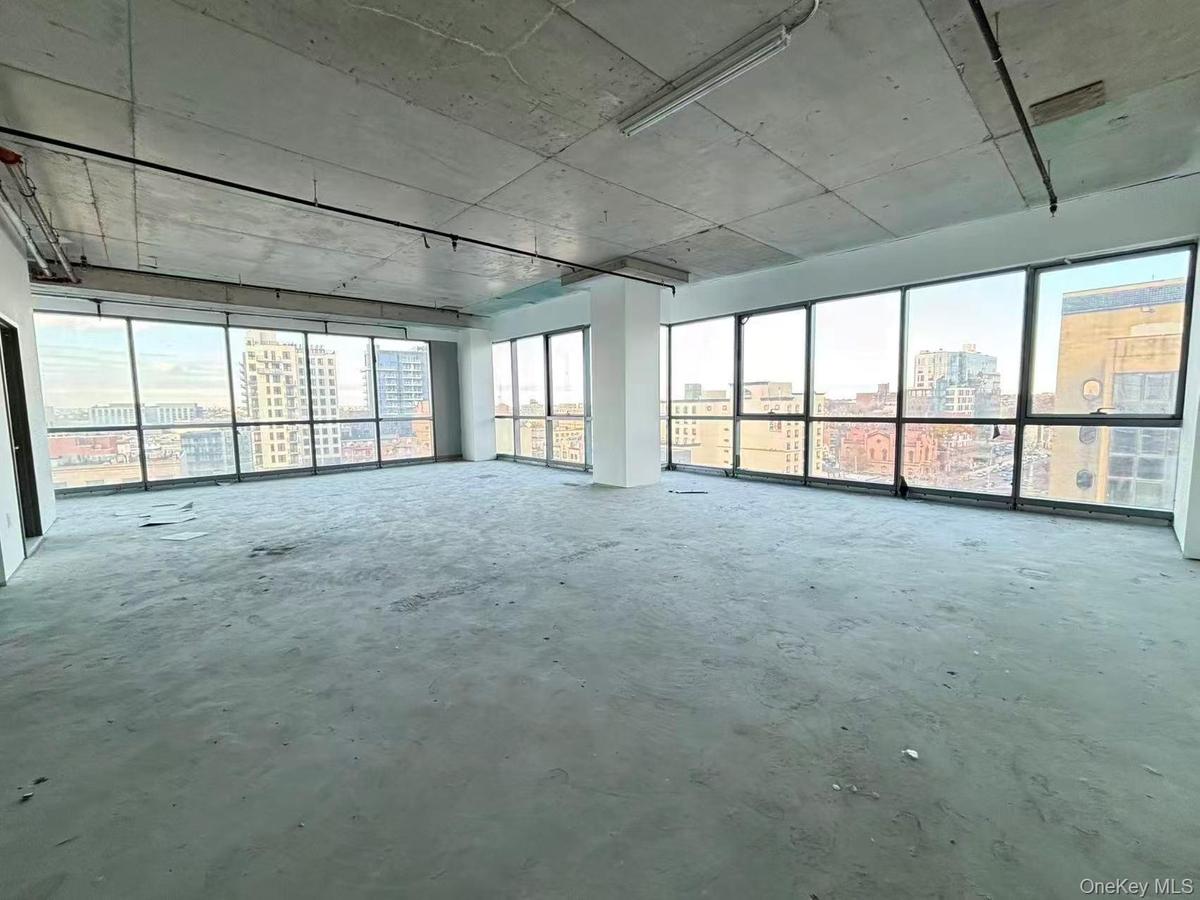 Empty room with a view of city and unfinished concrete floors