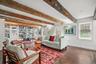 Living room featuring beamed ceiling and dark wood-type flooring