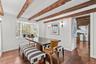 Dining space with beamed ceiling and dark wood-style floors