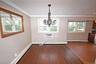 Unfurnished dining area with dark wood-type flooring, baseboard heating, crown molding, a chandelier, and recessed lighting