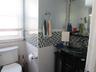 Half bathroom with vanity, tile walls, and a wainscoted wall