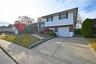 Split level home featuring brick siding, driveway, an attached garage, and a front lawn