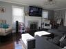 Living area featuring wood finished floors, a glass covered fireplace, and radiator