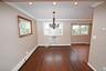 Unfurnished dining area featuring a baseboard radiator, healthy amount of natural light, crown molding, dark wood-type flooring, and a chandelier