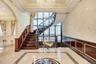 Stairs with inlaid floor details, ornamental molding, arched walkways, a chandelier, and tile patterned floors