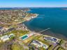 Aerial view of property and surrounding area with a pool area and nearby suburban area