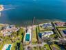 Aerial view of property and surrounding area featuring a pool area and nearby suburban area