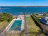 Drone / aerial view of a pool area and a nearby body of water