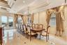 Dining room featuring a decorative wall, crown molding, a chandelier, a raised ceiling, and wainscoting