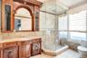 Bathroom with vanity, light tile patterned floors, tile walls, a shower stall, and tasteful backsplash