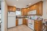 Kitchen with white appliances, brown cabinets, and recessed lighting