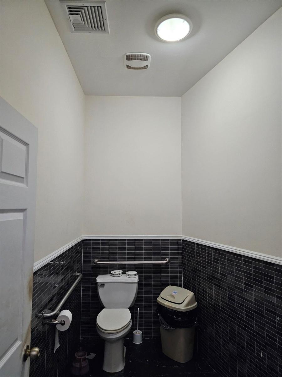 Bathroom with tile walls and wainscoting