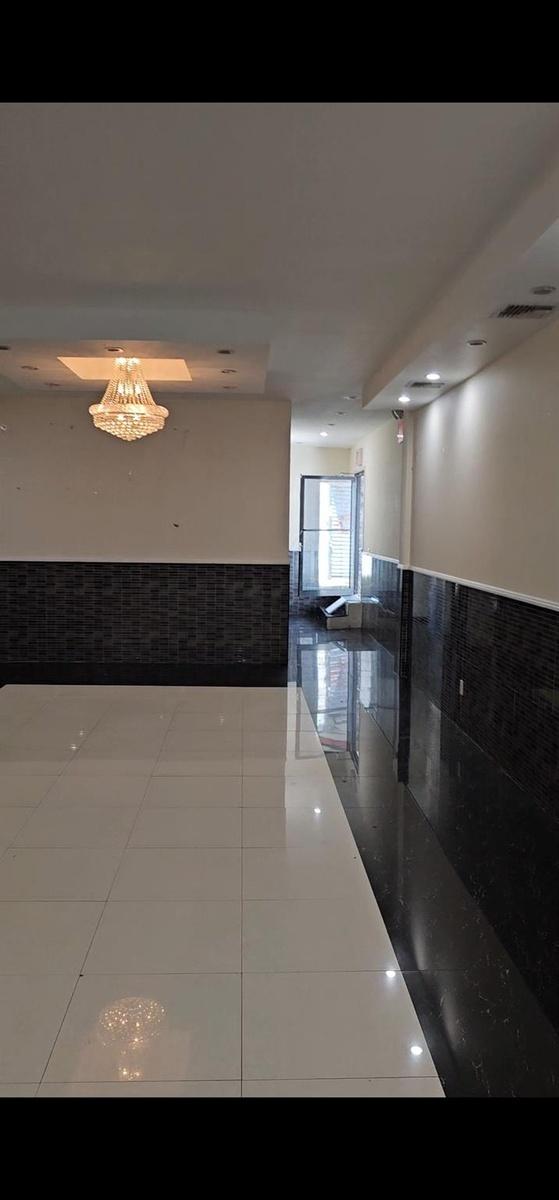 Corridor with wainscoting, tile patterned floors, and tile walls