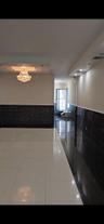 Corridor with wainscoting, tile patterned floors, and tile walls