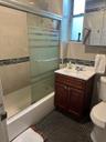 Bathroom with toilet, tile patterned floors, vanity, and enclosed tub / shower combo
