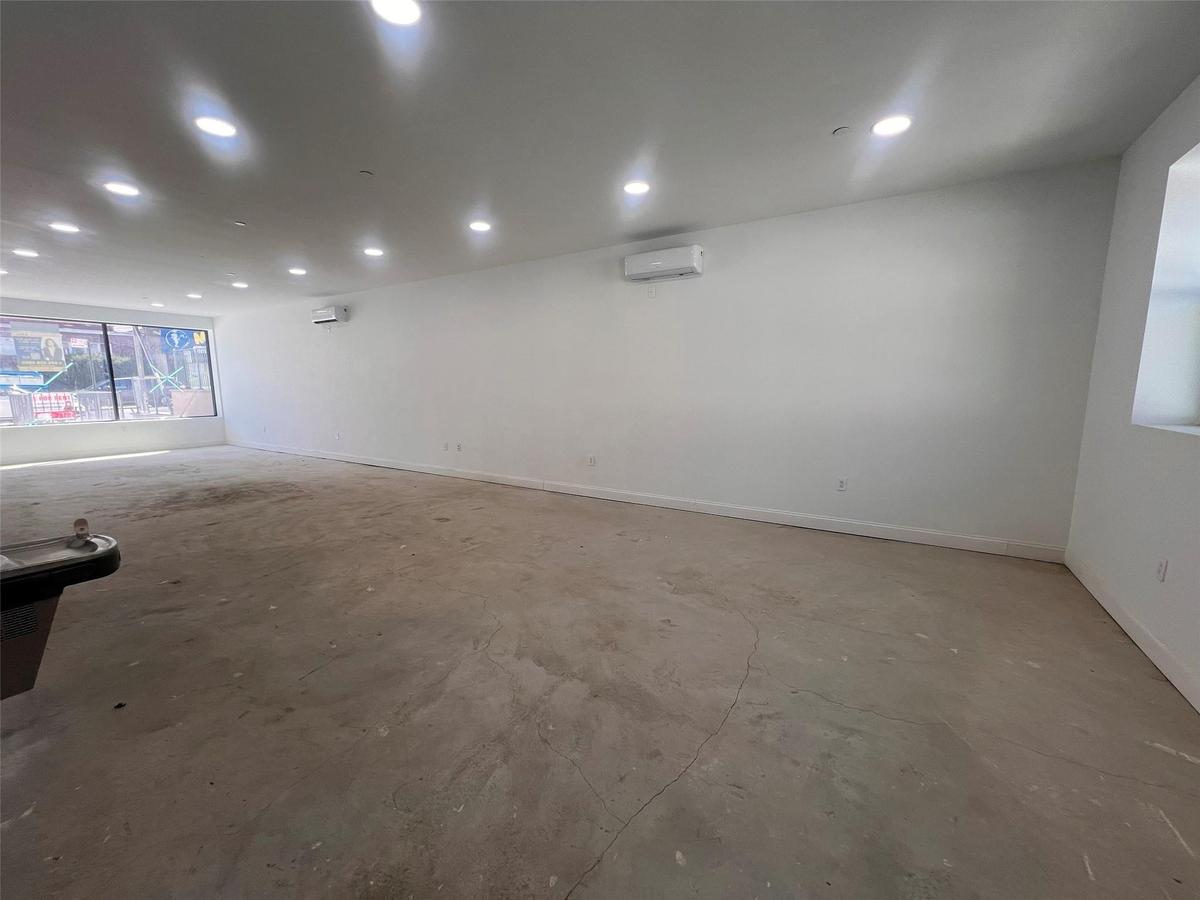 Spare room with an AC wall unit, concrete flooring, baseboards, and recessed lighting