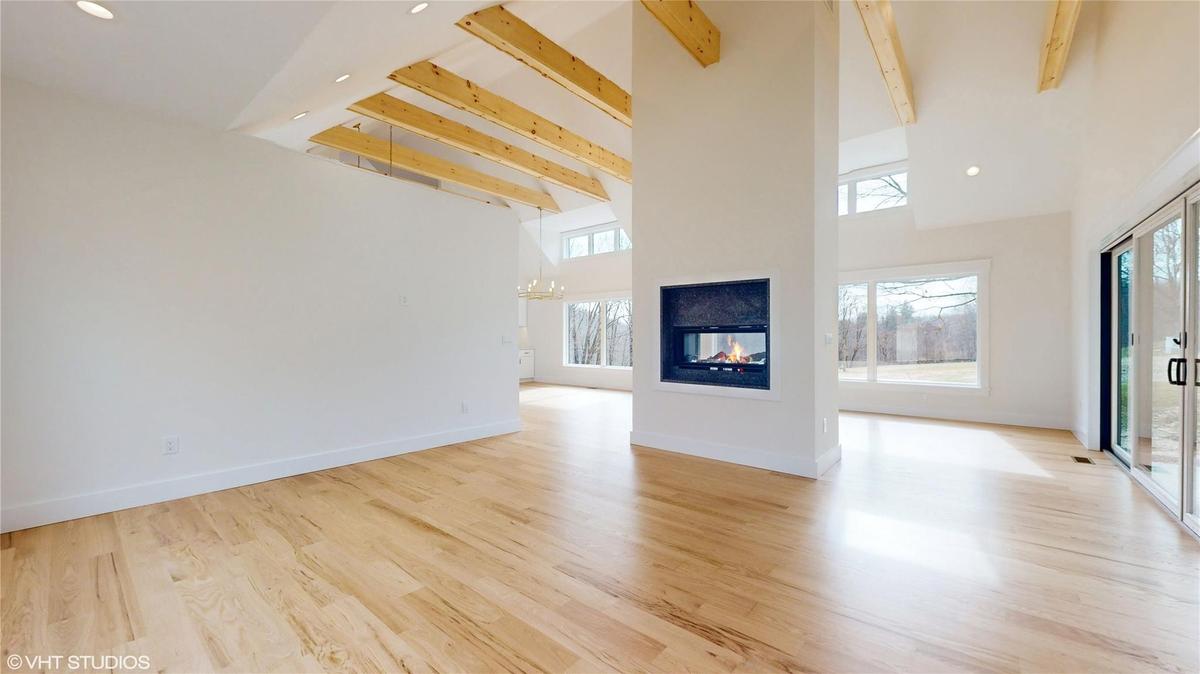 living room featuring beamed ceiling, light hardwood / wood-style floors