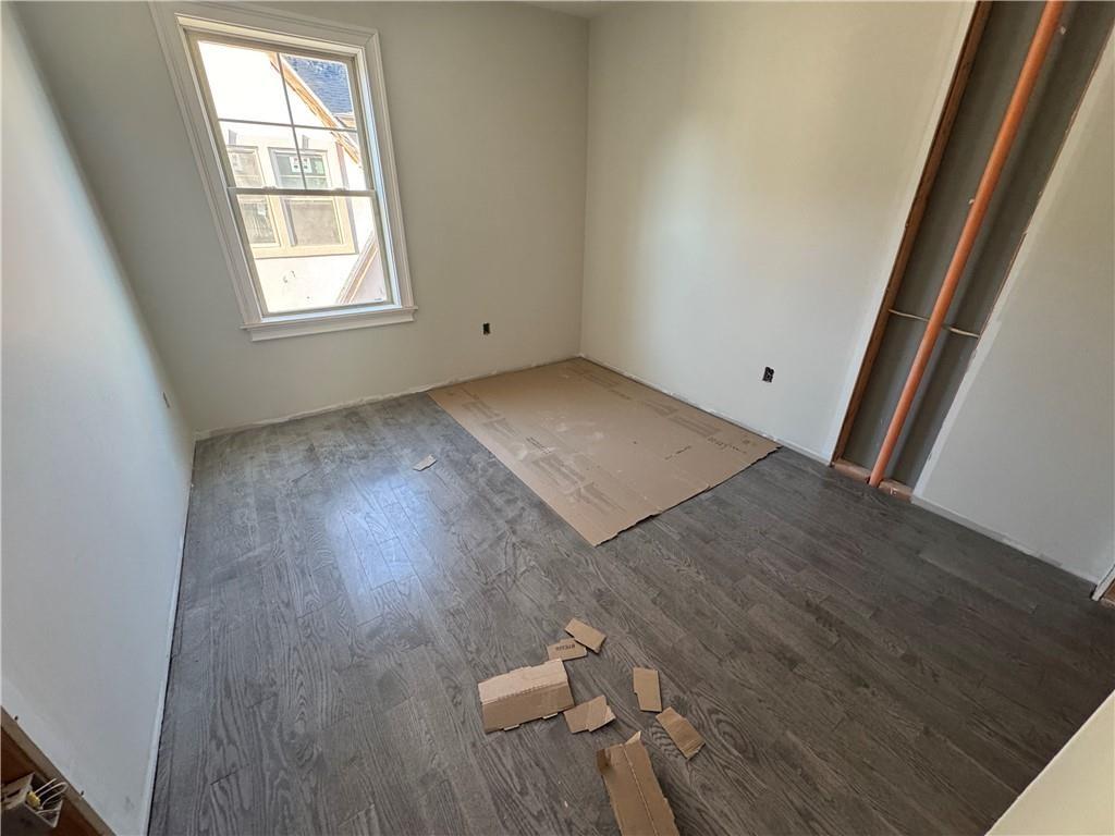 Spare room with dark hardwood / wood-style flooring
