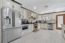Kitchen featuring stainless steel appliances, tasteful backsplash, glass insert cabinets, recessed lighting, and light wood-style floors