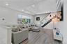 Living room featuring plenty of natural light, wood finished floors, recessed lighting, stairway, and a towering ceiling