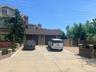 View of front of property featuring concrete driveway, brick siding, and a chimney