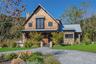 View of front of house featuring a standing seam roof, a metal roof, and a chimney