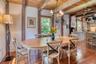 Dining room with a wood ceiling with exposed beams, hardwood / wood-style floors, ceiling fan, healthy amount of natural light, and a chandelier